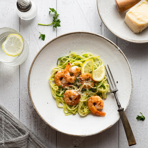 Spiralized zucchini noodles pasta with shrimps on gray background, view from above