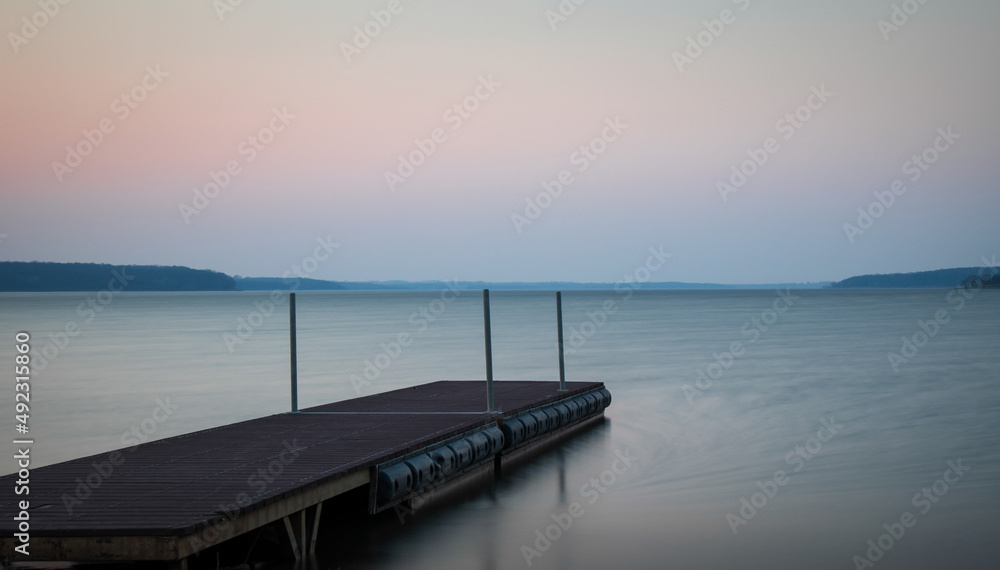 Fototapeta premium A dock on a lake after sunset