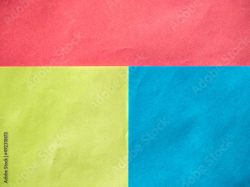 Geometric abstract multicolored paper background. Sheets of red, yellow and blue paper lie on top of each other and form rectangles. Background with paper texture