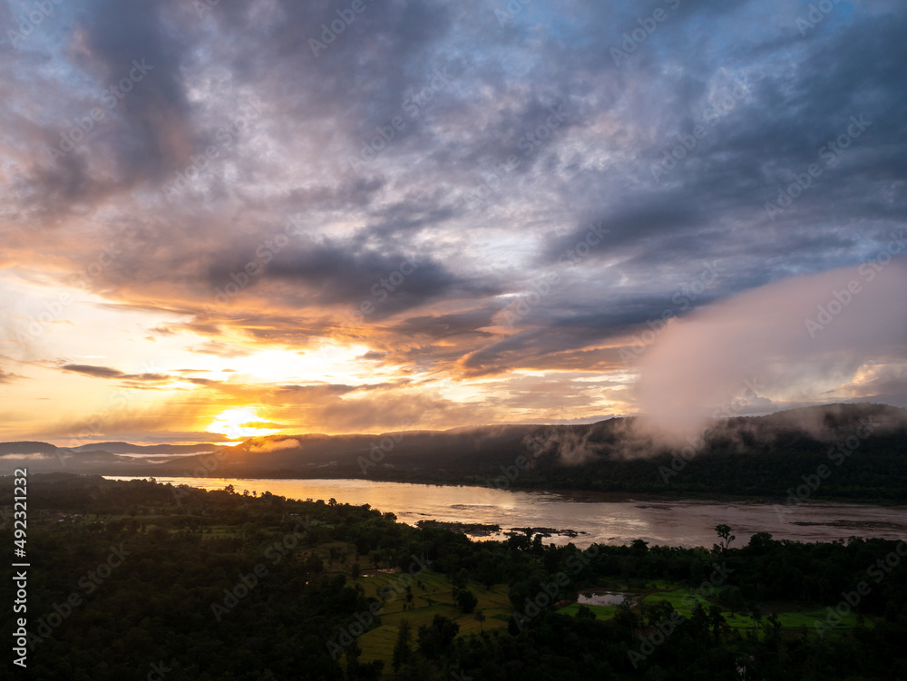 Fototapeta premium Sunrise over The Mountain with The River and The Fog