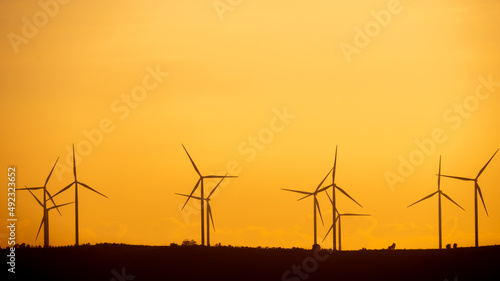 Silhouette Wind Turbines Standing on Top of The Mountain photo