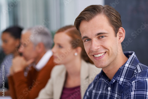Hes found his place within the company. A young businessman smiling while in a work meeting.