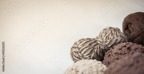 Knitted from a vintage brown yarn sweater and thread for knitting closeup. Knitting as a hobby. Accessories for knitting. Knitting yarn for handmade winter clothes. top view table concept. flat lay.