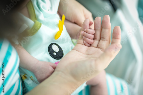 The newborn uses her small hand to hold the mother's little finger to ensure that she is always together.