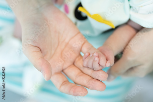 The newborn uses her small hand to hold the mother's little finger to ensure that she is always together.