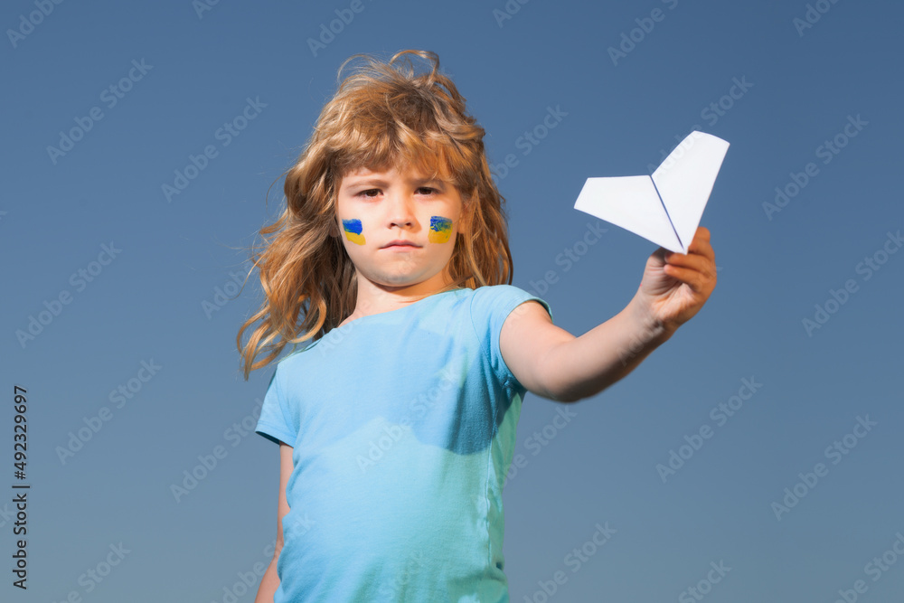 Close the sky over Ukraine banner. No fly zone over Ukraine. Ukraine flag on kids cheek. Close the sky over Ukraine banner. No fly zone over Ukraine. Ukraine flag on kids cheek.