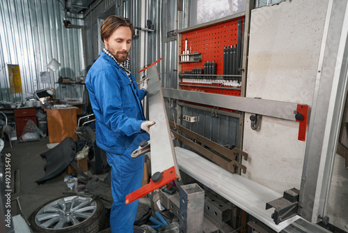 Worker holding special tool for auto repair © Svitlana