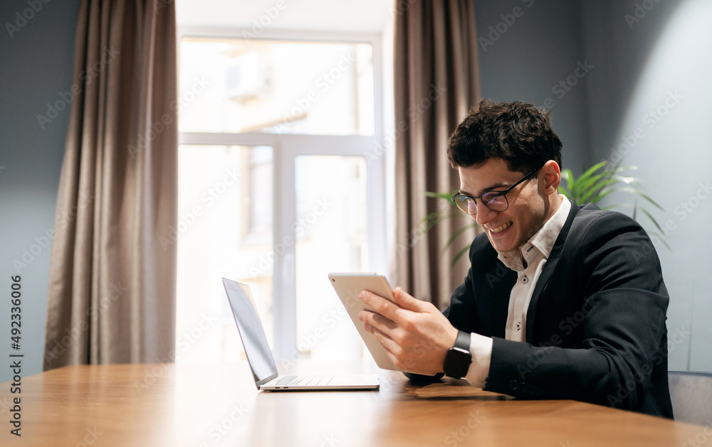 A male manager works in an office coworking space, uses a laptop and writes a letter to a client A male manager works in an office coworking space, uses a laptop and writes a letter to a client