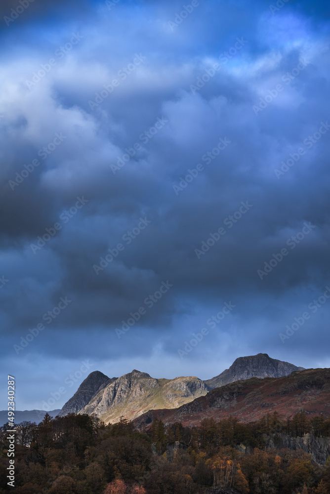 Fototapeta premium Majestic landscape image of stunning Autumn sunset light across Langdale Pikes looking from Holme Fell in Lake District