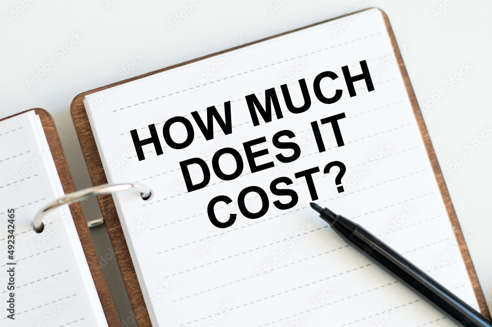 How Much Does it Cost. Business concept. text on white notepad paper. How Much Does it Cost. Business concept. text on white notepad paper.