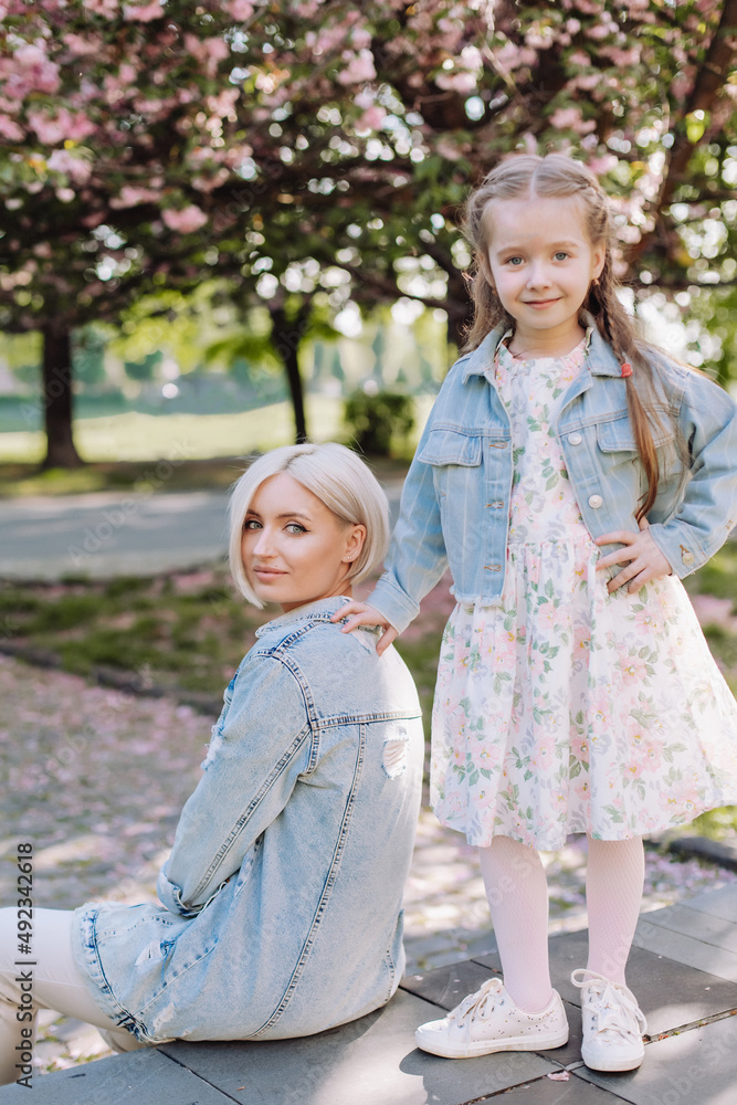 Sakura blossomed. Young mother with her child have fun in the park near the sakura. cherry trees blossom (Uzhhorod City, Ukraine) Sakura blossomed. Young mother with her child have fun in the park near the sakura. cherry trees blossom (Uzhhorod City, Ukraine)