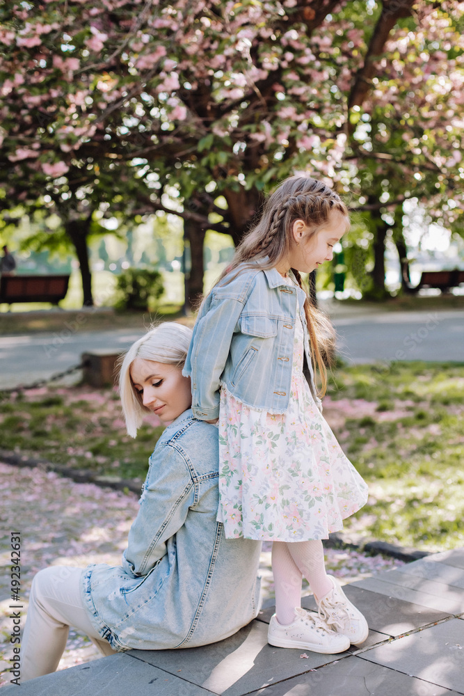 Sakura blossomed. Young mother with her child have fun in the park near the sakura. cherry trees blossom (Uzhhorod City, Ukraine) Sakura blossomed. Young mother with her child have fun in the park near the sakura. cherry trees blossom (Uzhhorod City, Ukraine)