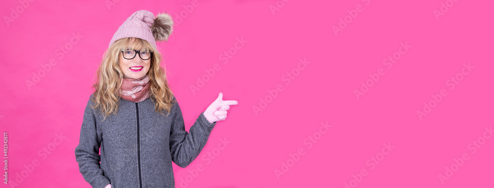 woman in winter clothes, sweater, hat, gloves and scarf pointing or showing with copy space woman in winter clothes, sweater, hat, gloves and scarf pointing or showing with copy space