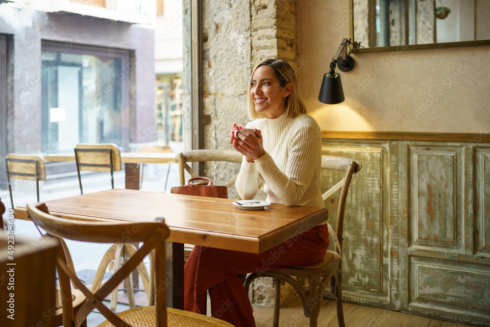 Delighted woman with coffee in cafe