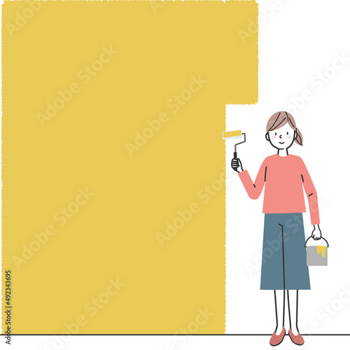 壁にペンキを塗る女性