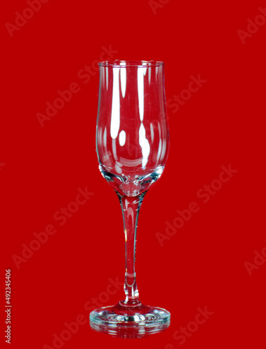 On a red background a beautiful glass for alcohol