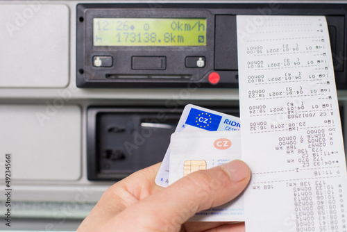 Olomouc Czech Rep Jan 7th 2021 Hand holding a driver digital card, drivers licence infront of a digital tachograph. No personal data