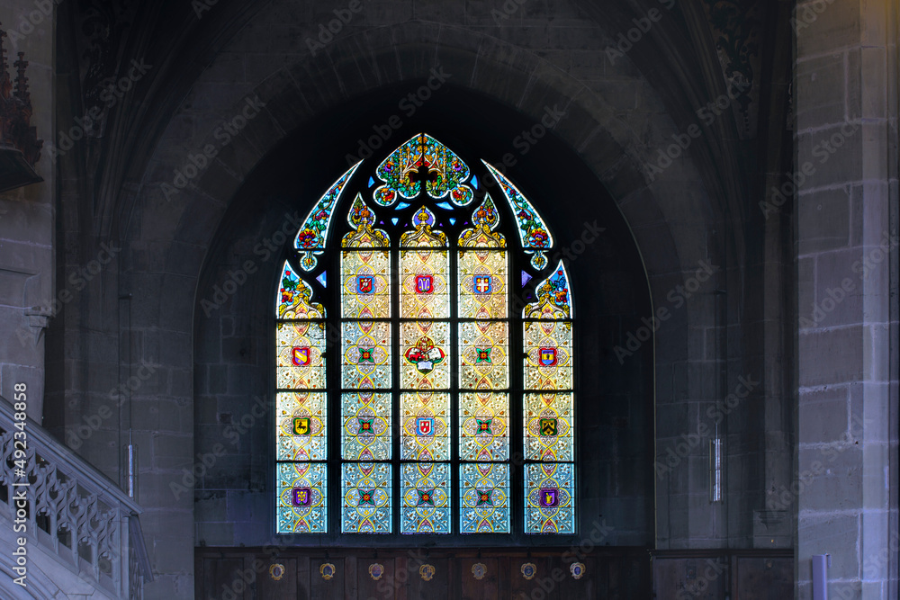 Multicolor stain glass window at Bern Minster. Architectural detail of Swiss Reformed cathedral, in Bern. Swiss gothic art.