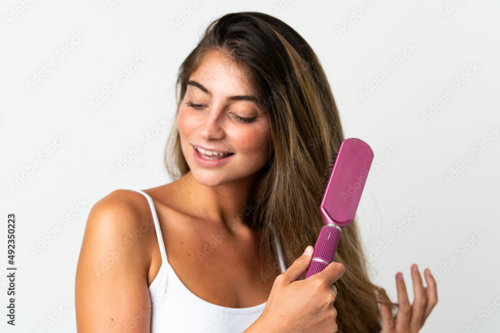Young caucasian woman isolated on white background with hair comb Young caucasian woman isolated on white background with hair comb