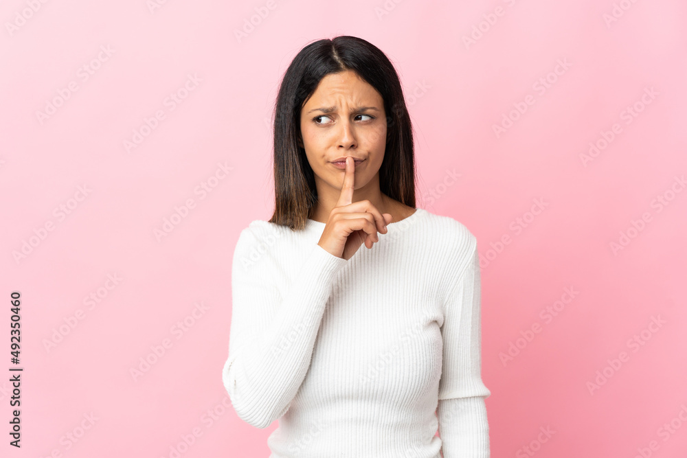 Caucasian girl isolated on pink background showing a sign of silence gesture putting finger in mouth Caucasian girl isolated on pink background showing a sign of silence gesture putting finger in mouth