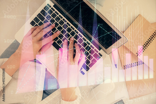 Double exposure of woman hands working on computer and forex graph hologram drawing. Top View. Financial analysis concept. © peshkova