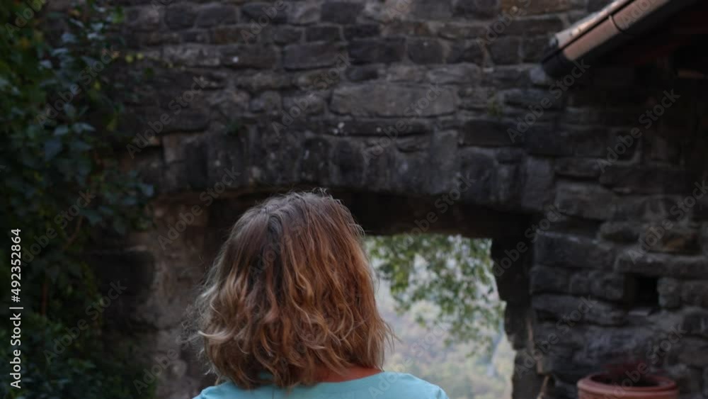 a woman walks along a city street, a tourist looks at the sights of the city, a woman walks a back view a woman walks along a city street, a tourist looks at the sights of the city, a woman walks a back view