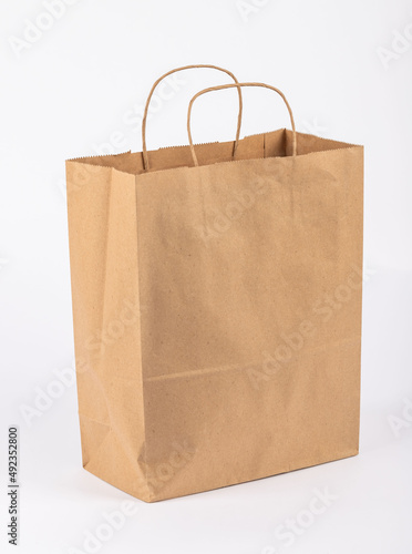 paper shopping bag. Kraft bag. It stands on a white background. Taken in detail from close-up.