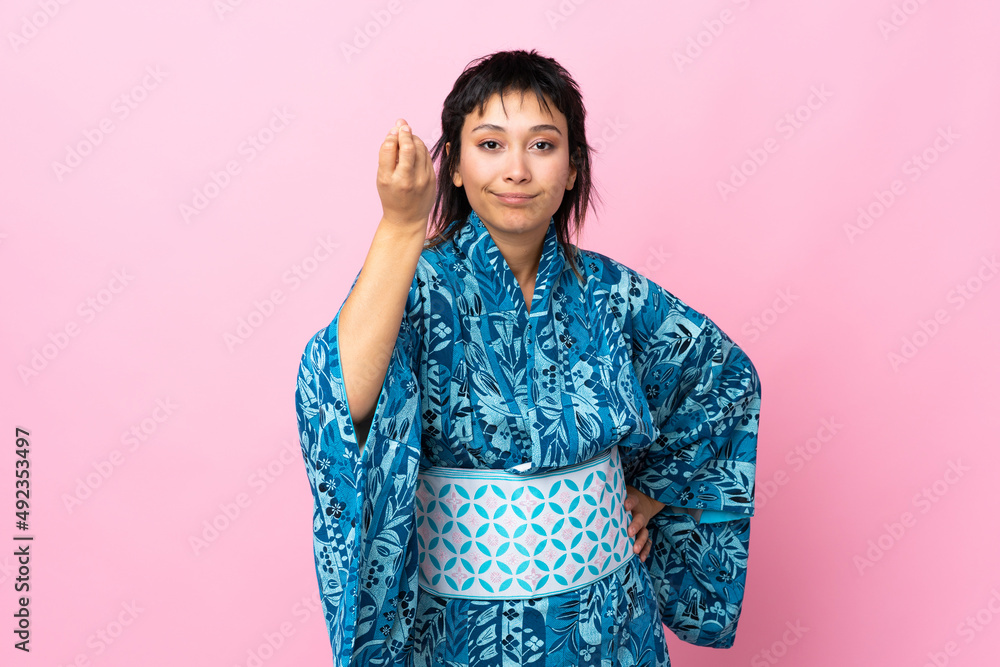 Young woman wearing kimono over isolated blue background making Italian gesture Young woman wearing kimono over isolated blue background making Italian gesture