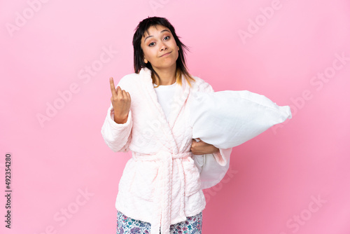 Young Uruguayan woman in pajamas over isolated pink background pointing with the index finger a great idea