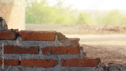 Unconventional building site The masonry was neglected, irresponsible, not progressing, only half finished. Some parts, the walls had rough surfaces.