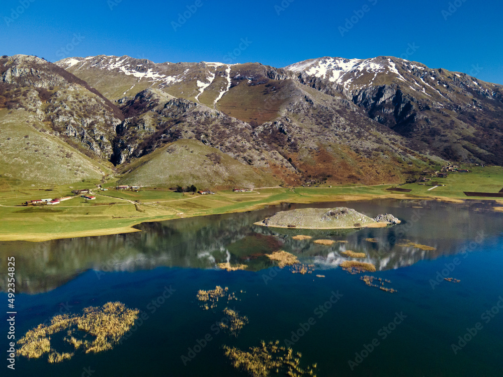 View of the mountain lake. Snowy mountains are displayed in a crystal clear lake. Lake Matese, province of Caserta Italy