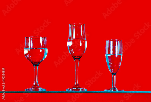 arious drinks filled with water are placed on a bright red background