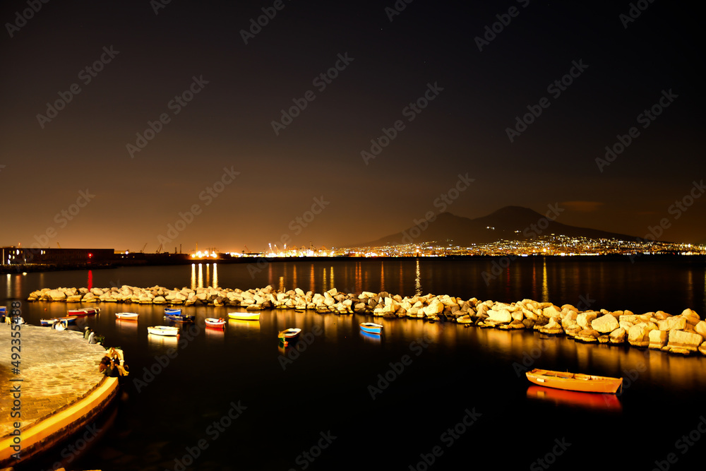 Obraz premium Night view of small boats visible from the waterfront of the Italian city.