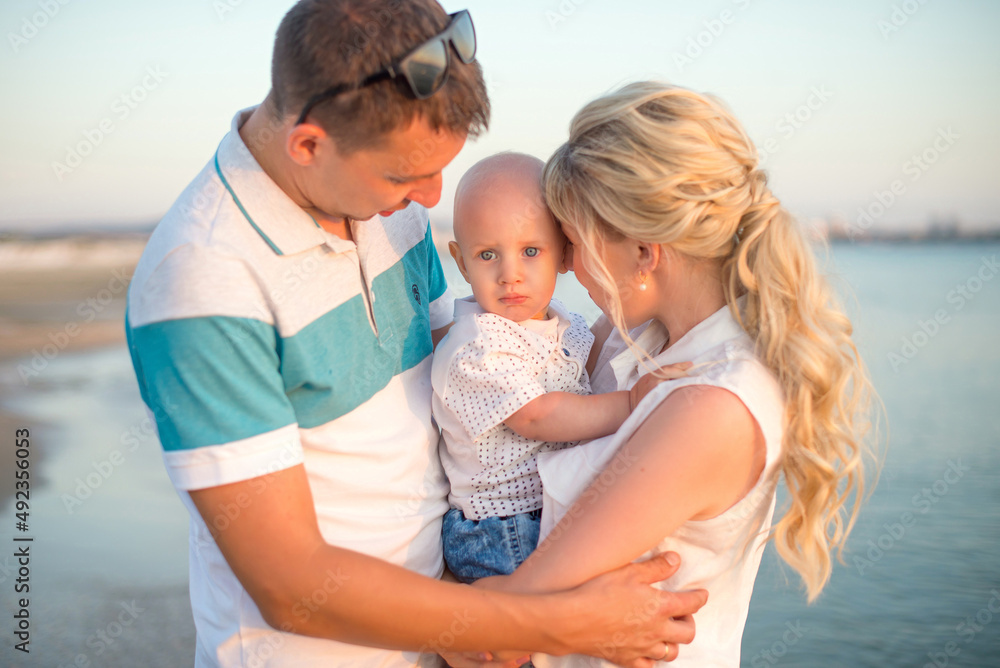 A happy family with a small child on the background of a beautiful sea sunset. Anapa, Russia A happy family with a small child on the background of a beautiful sea sunset. Anapa, Russia