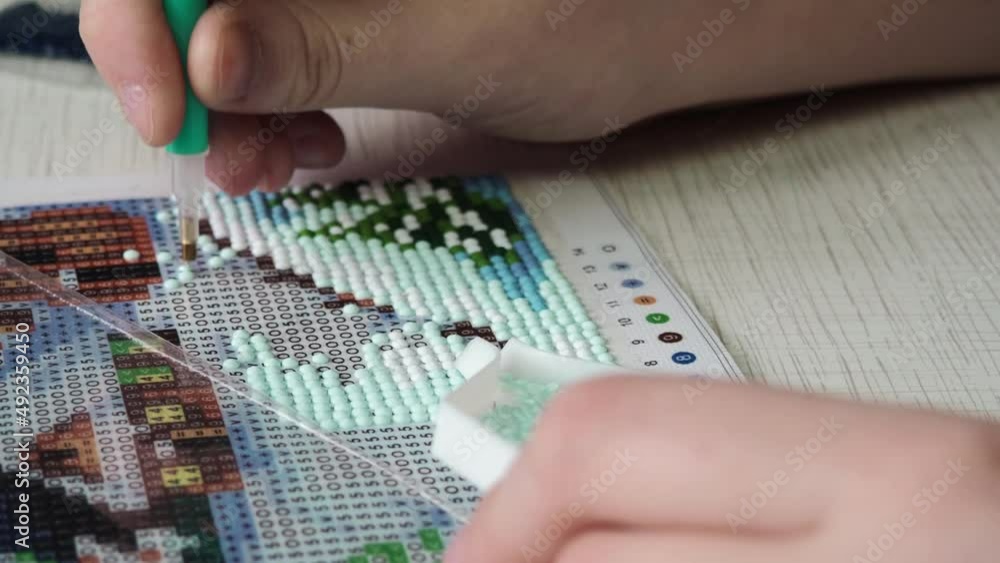 The process of creating a picture of rhinestones,hobby.Close-up of a child's hands The process of creating a picture of rhinestones,hobby.Close-up of a child's hands
