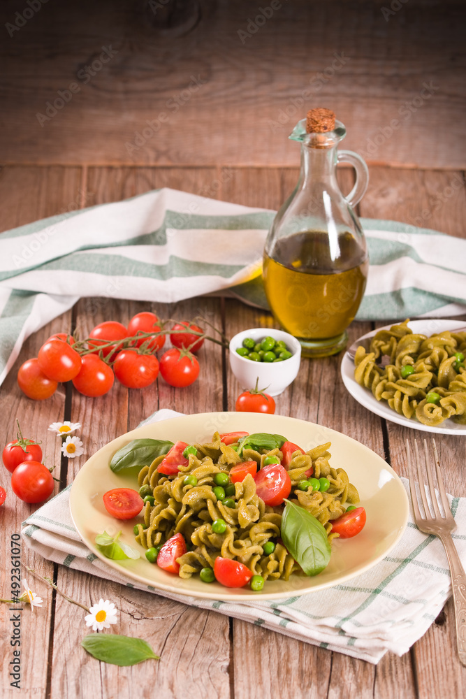 Fusilli pasta with cherry tomatoes and peas.
