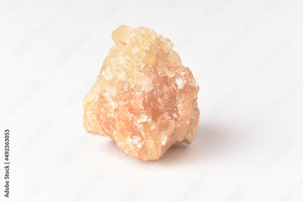 One uncut and rough Sunstone crystal,quartz on white One uncut and rough Sunstone crystal,quartz on white