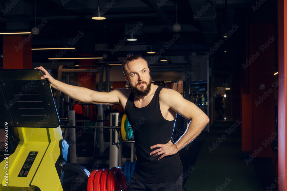 Young man with a beard posing in the gym Young man with a beard posing in the gym