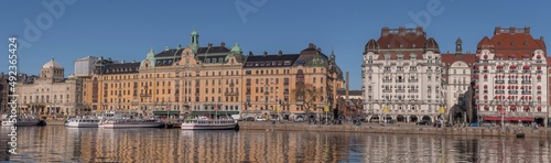  Panorama view at the water front pier with apartment and hotel houses, commuting boats in in the calm water bay Ladugårdsviken a sunny winter day in Stockholm