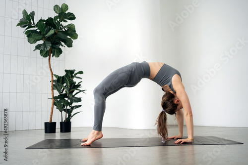 Exercises aerobics pose yoga asana female trainer workout in fitness club. Balance of spirit and flexible body