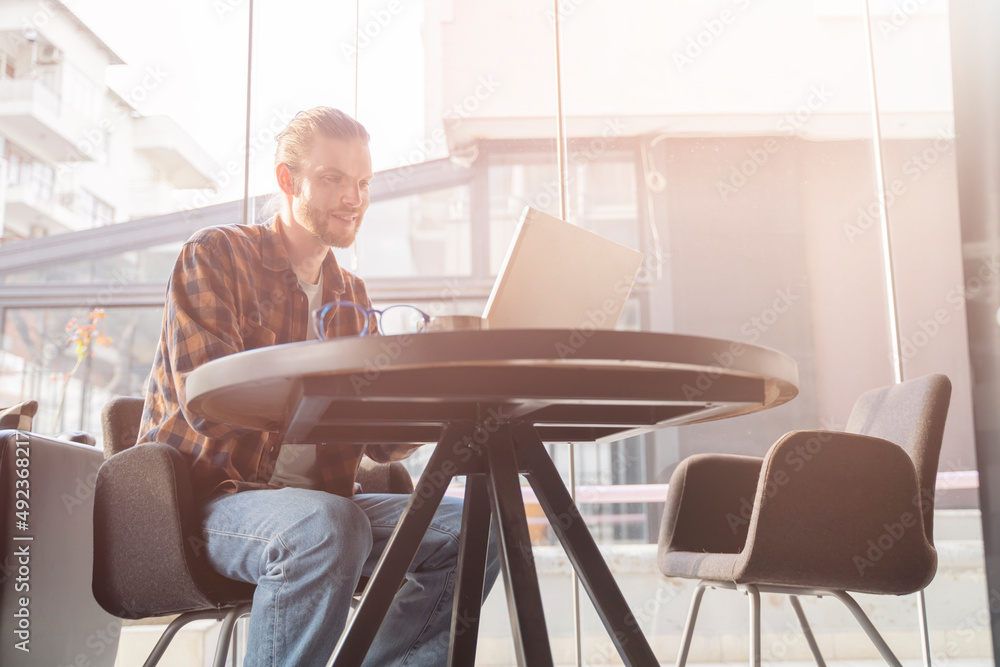 man freelancer working on a laptop in cafe