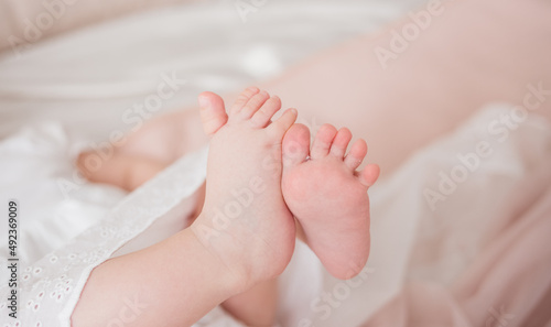 close-up of a child's bare feet on a bed in a room © Яна Айбазова