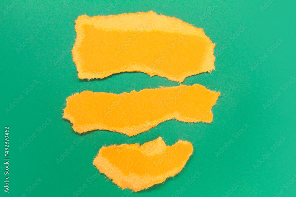 three torn pieces of orange paper. the concept of copy space for writing