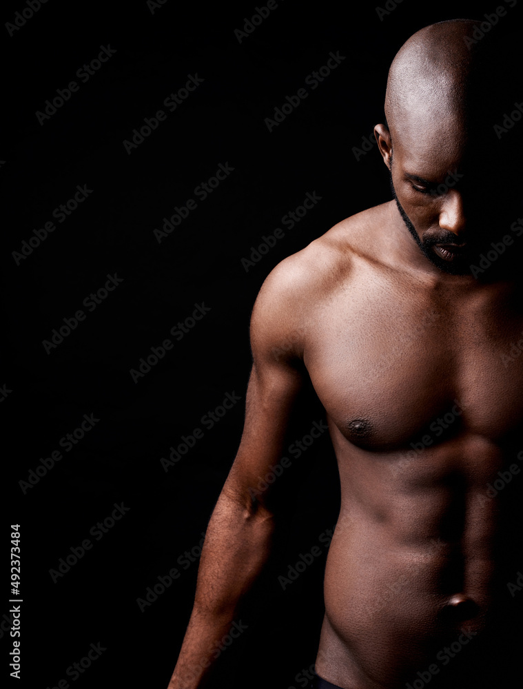 He pushes the limits of perfection. Cropped shot of a muscular man looking down. He pushes the limits of perfection. Cropped shot of a muscular man looking down.