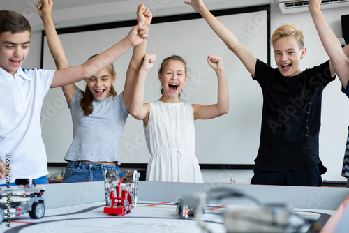Slika na platnu Children in robotics classes celebrate victory