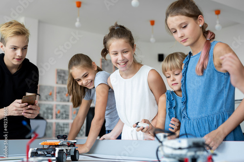 Close-up of children controlling robots using the remote control in a robotics lesson at school