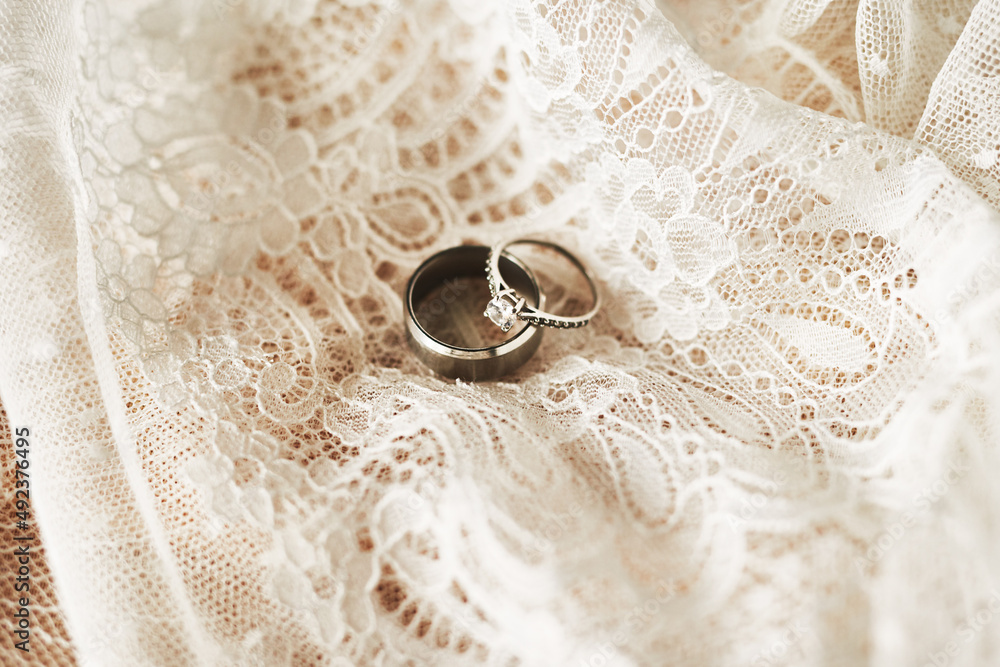 They symbolize our lifelong commitment to each other. Still life shot of two beautiful wedding rings on top of a wedding dress. They symbolize our lifelong commitment to each other. Still life shot of two beautiful wedding rings on top of a wedding dress.