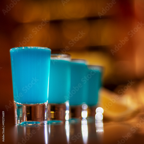 blue kamikaze shots on wooden table close up square photo