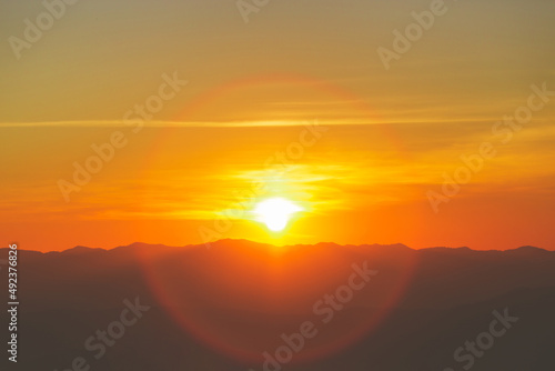Sunrise or sunset over mountain hill forest with beautiful circle Lens flare.