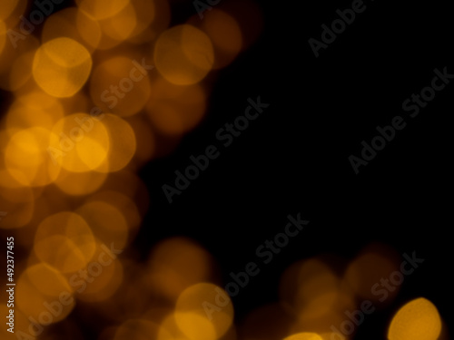 Abstract blur image of golden or yellow light of beautiful bokeh on black background with copy space. Blurred festive, night party and celebration bokeh background.